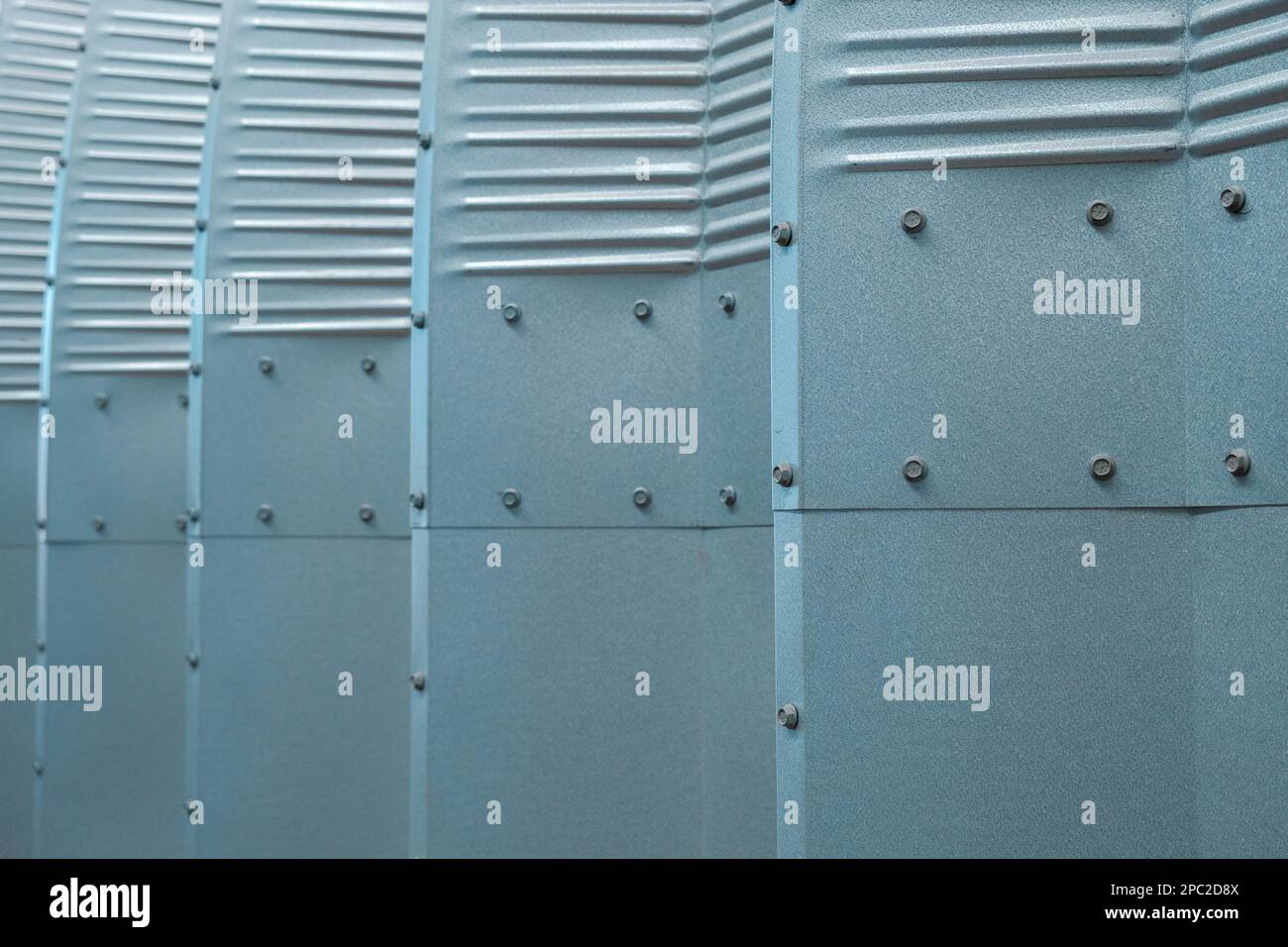 Metal sheets in light blue and green with folds and nuts protect exterior. Stock Photo