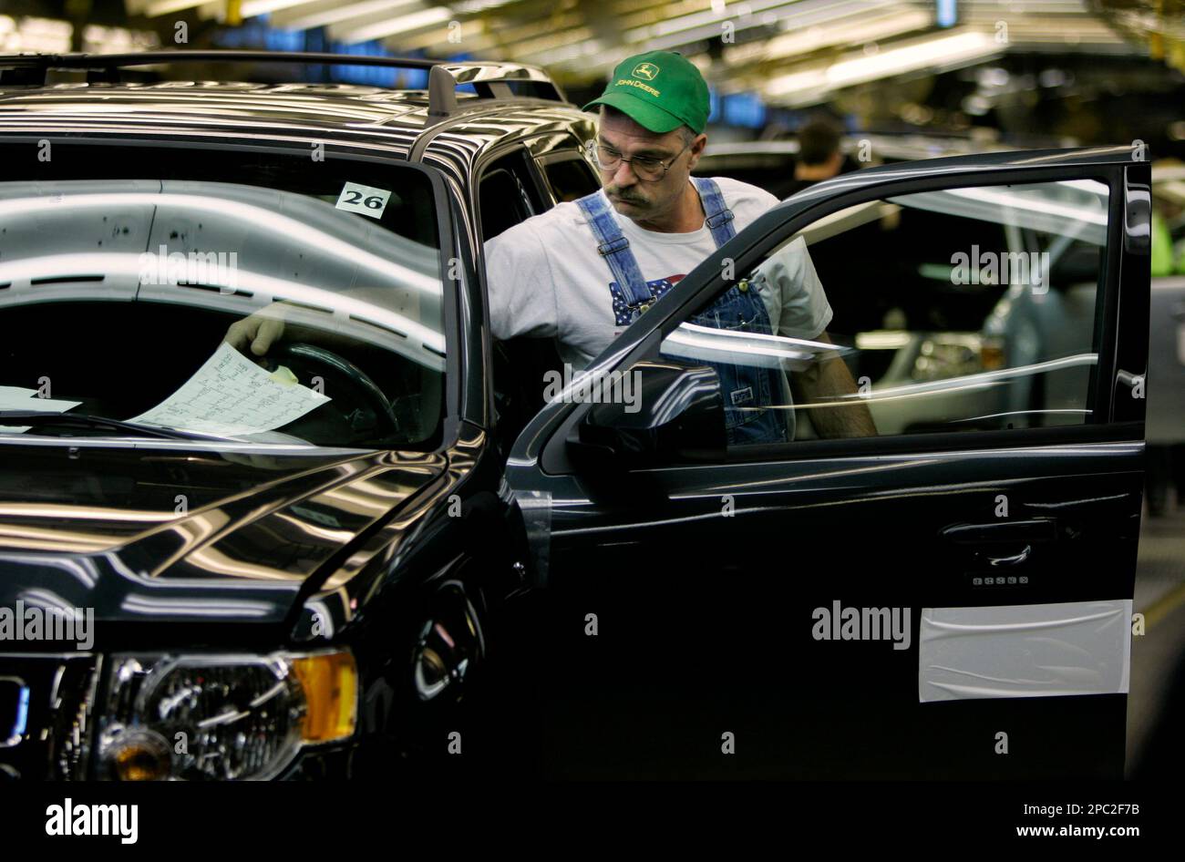 An auto worker works on a 2008 Ford Escape at the Ford Kansas City Assembly plant Friday, Jan