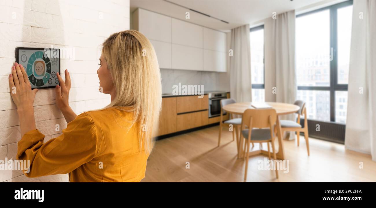 Woman using smart wall home control system Stock Photo
