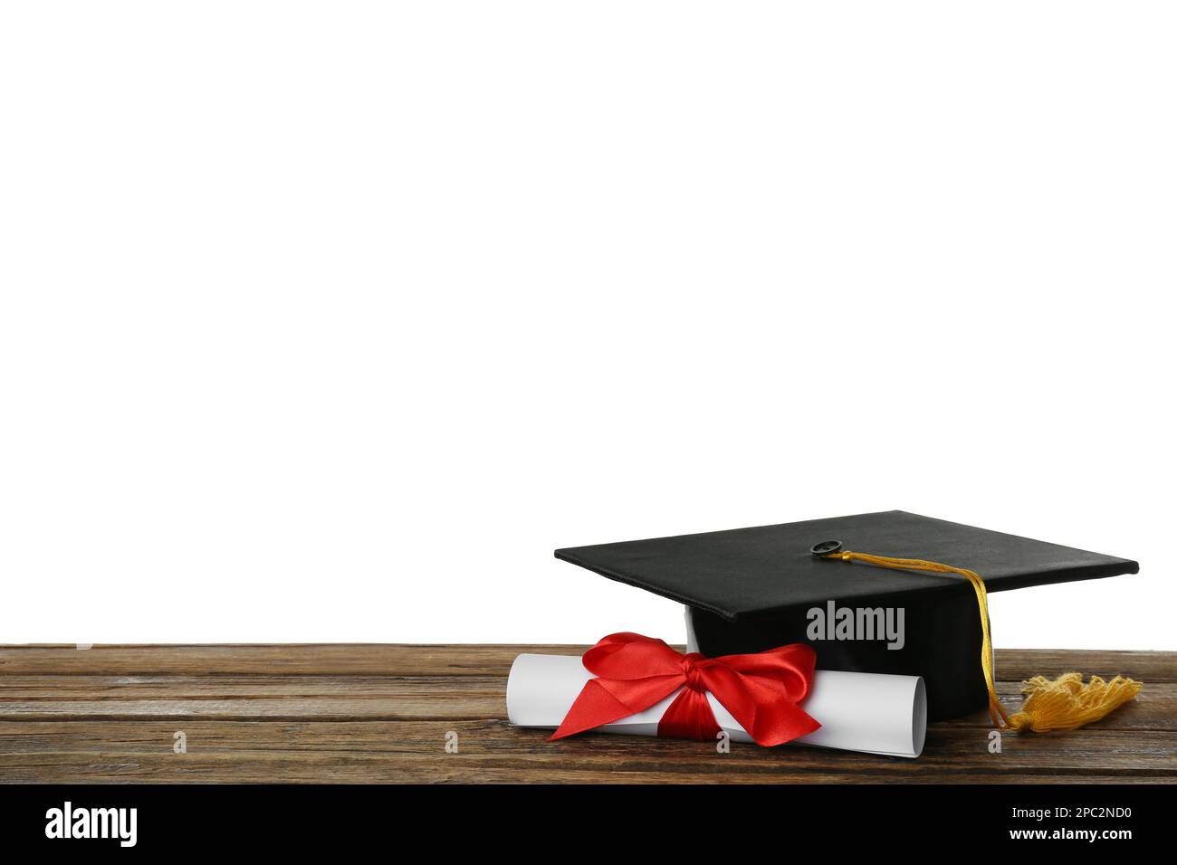 Graduation hat and diploma on wooden table against white background ...