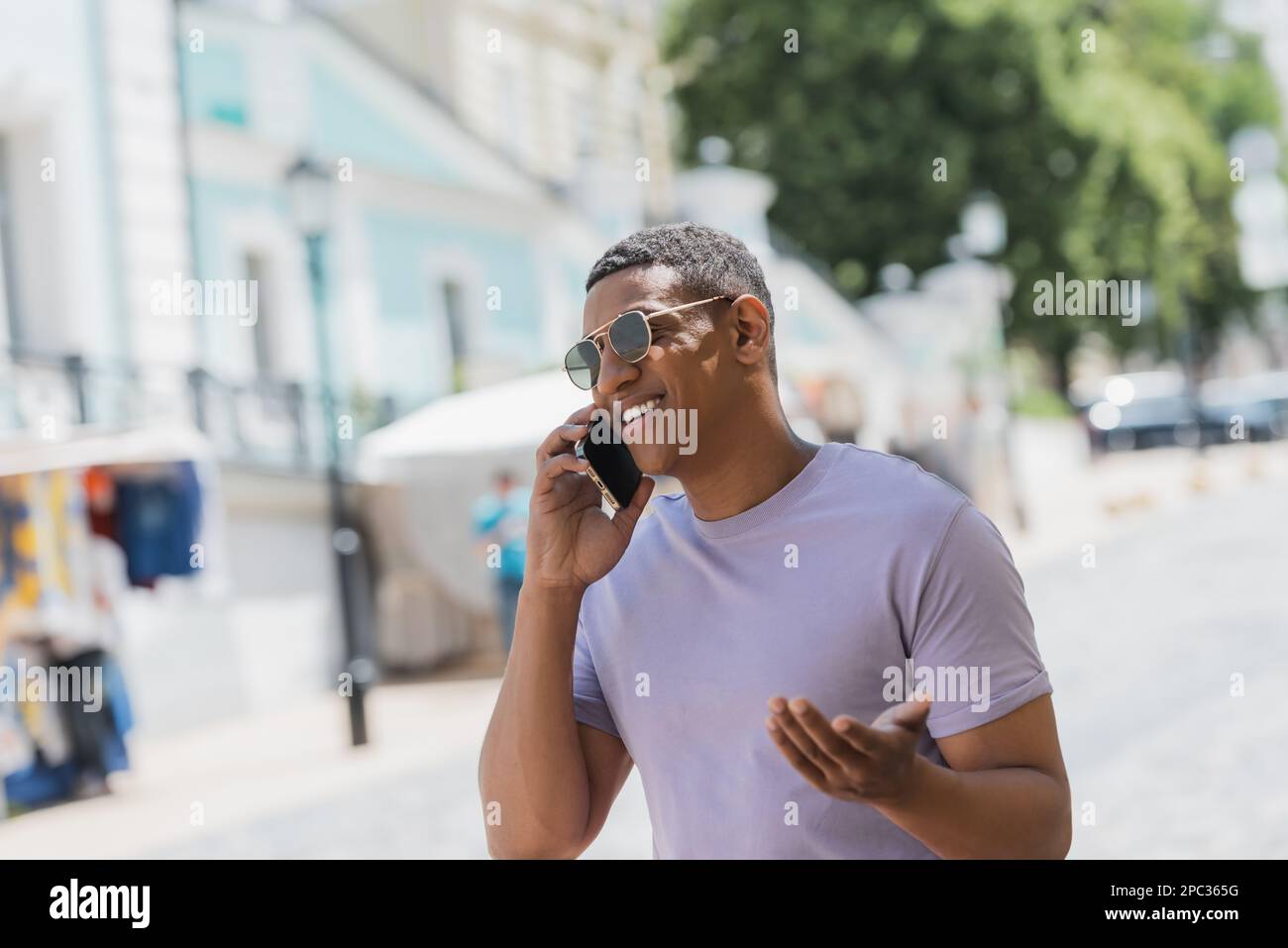 Happy african american man in sunglasses talking on smartphone on urban street in summer,stock image Stock Photo