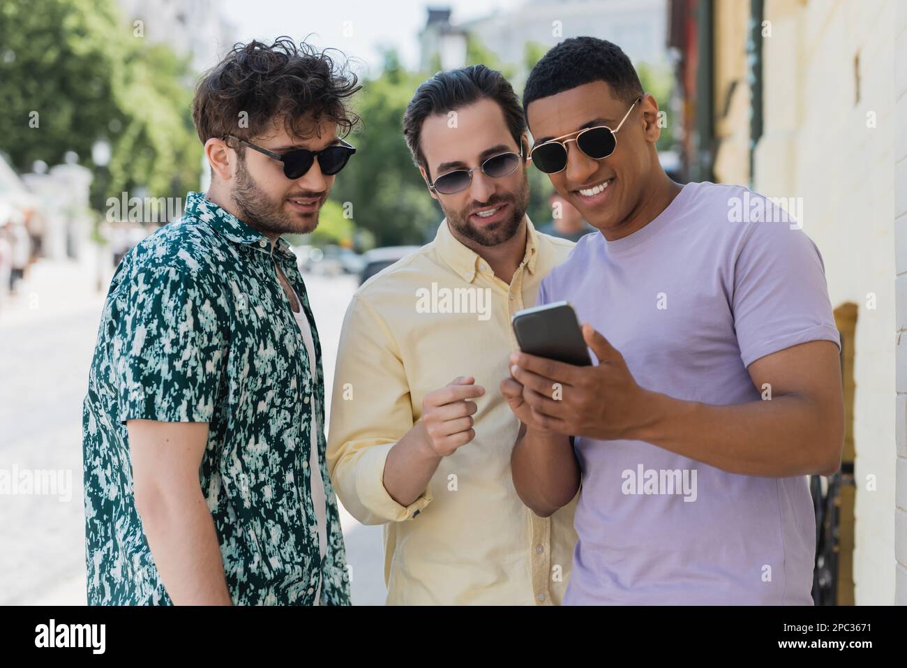 Multiethnic friends using mobile phone on urban street in summer,stock image Stock Photo