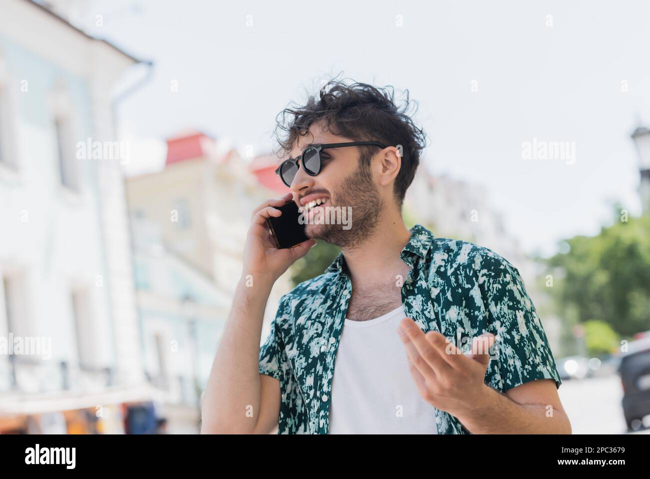Bearded man in sunglasses talking on cellphone on urban street in summer,stock image Stock Photo