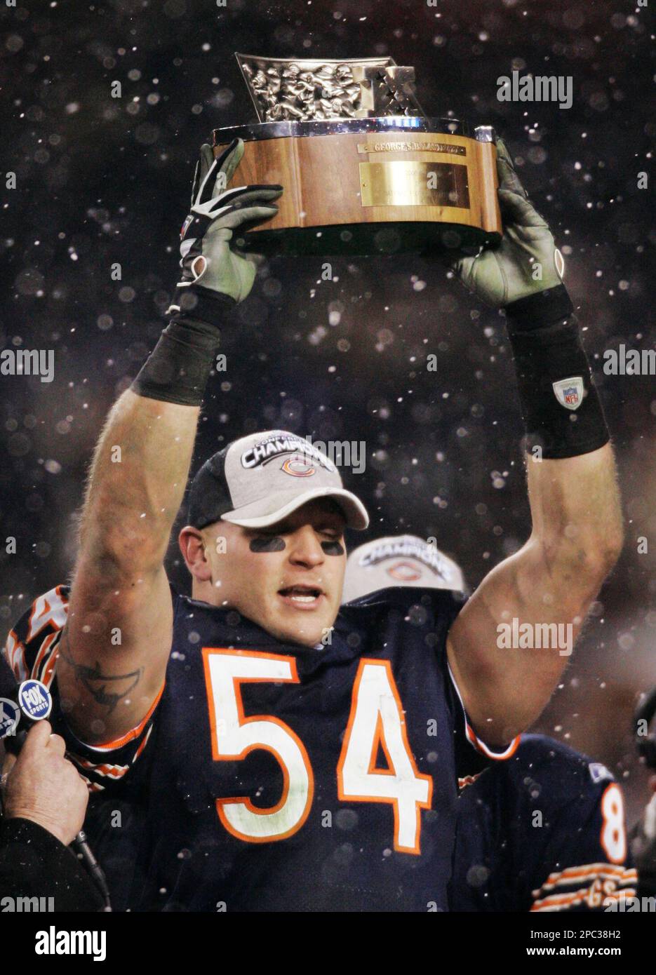 Chicago Bears' Brian Urlacher (54) holds up the NFC Championship Trophy  after the Bears beat the New Orleans Saints 39-14 in the NFC Championship  game at Soldier Field in Chicago on January