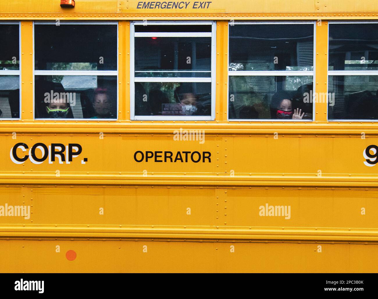 Children wearing masks during Covid riding a school bus Stock Photo