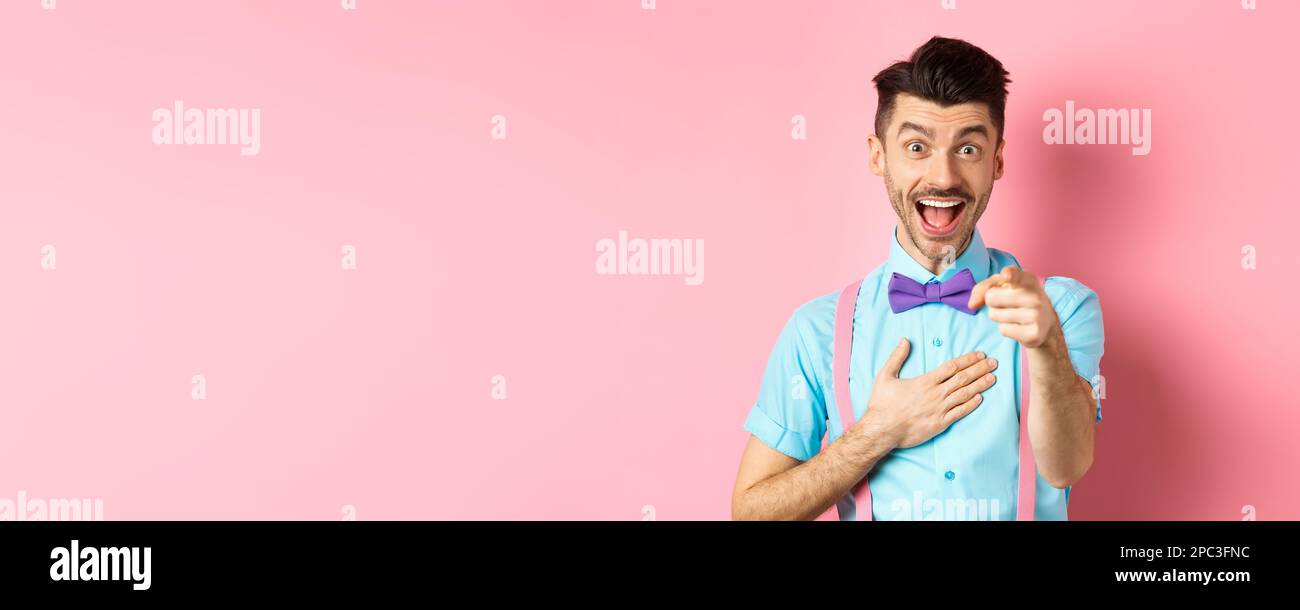 Funny guy laughing at something hilarious, smiling amazed and pointing