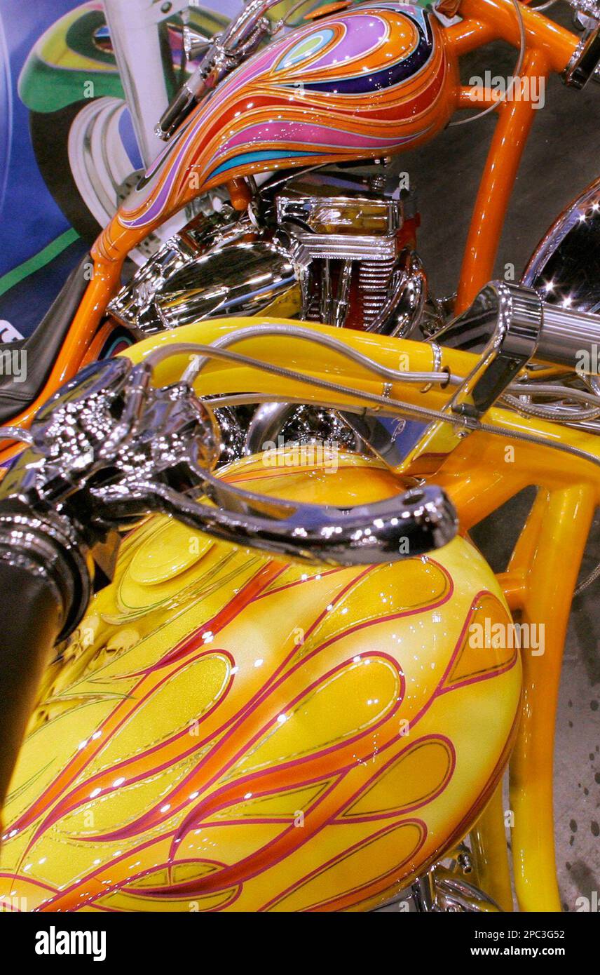 Custom motorcycles with colorful gas tanks are on display during the