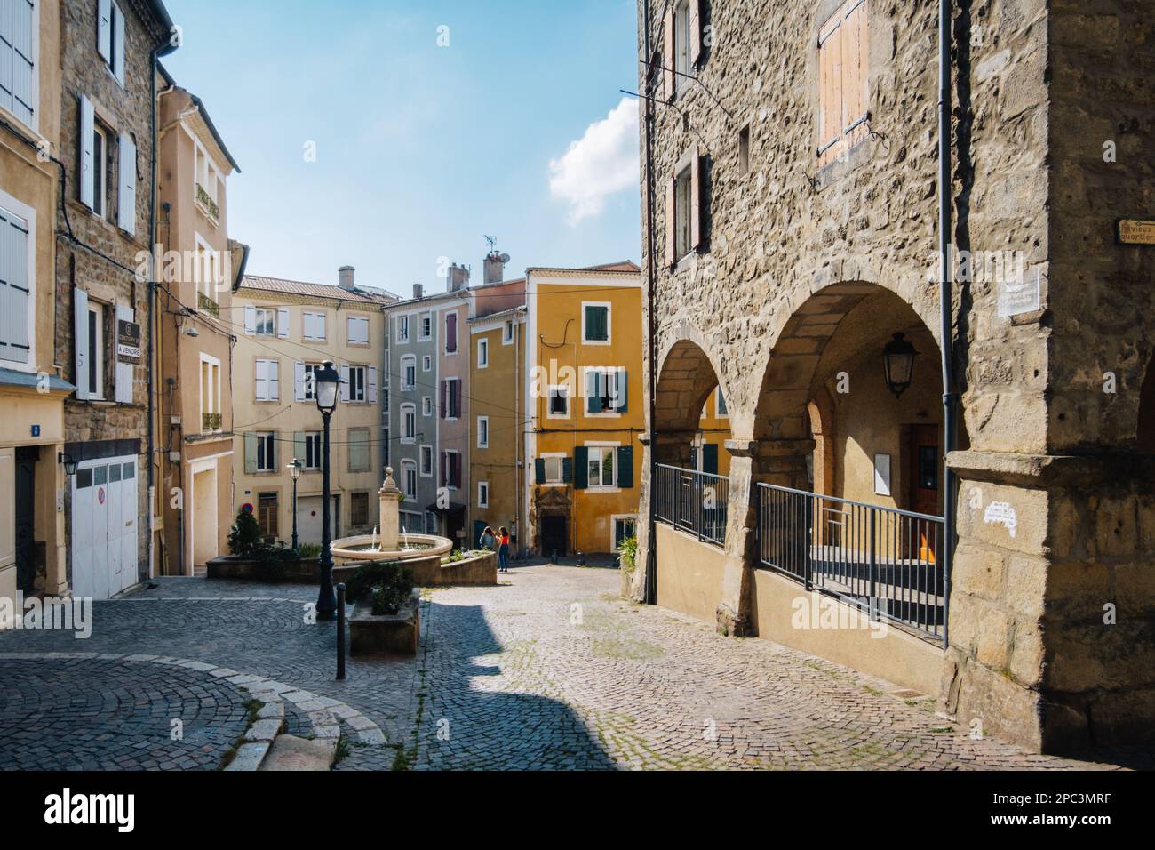 Place de la Grenette, a quaint square in Annonay (Ardeche, France) with its medieval covered market, fountain and colorful coated houses Stock Photo