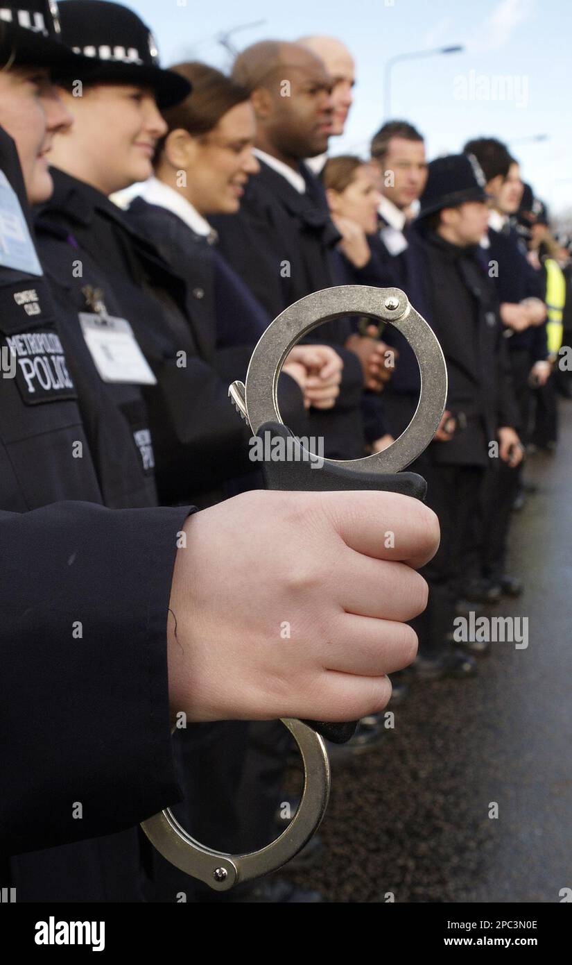 A police police officer prepares his handcuffs, before taking part in ...