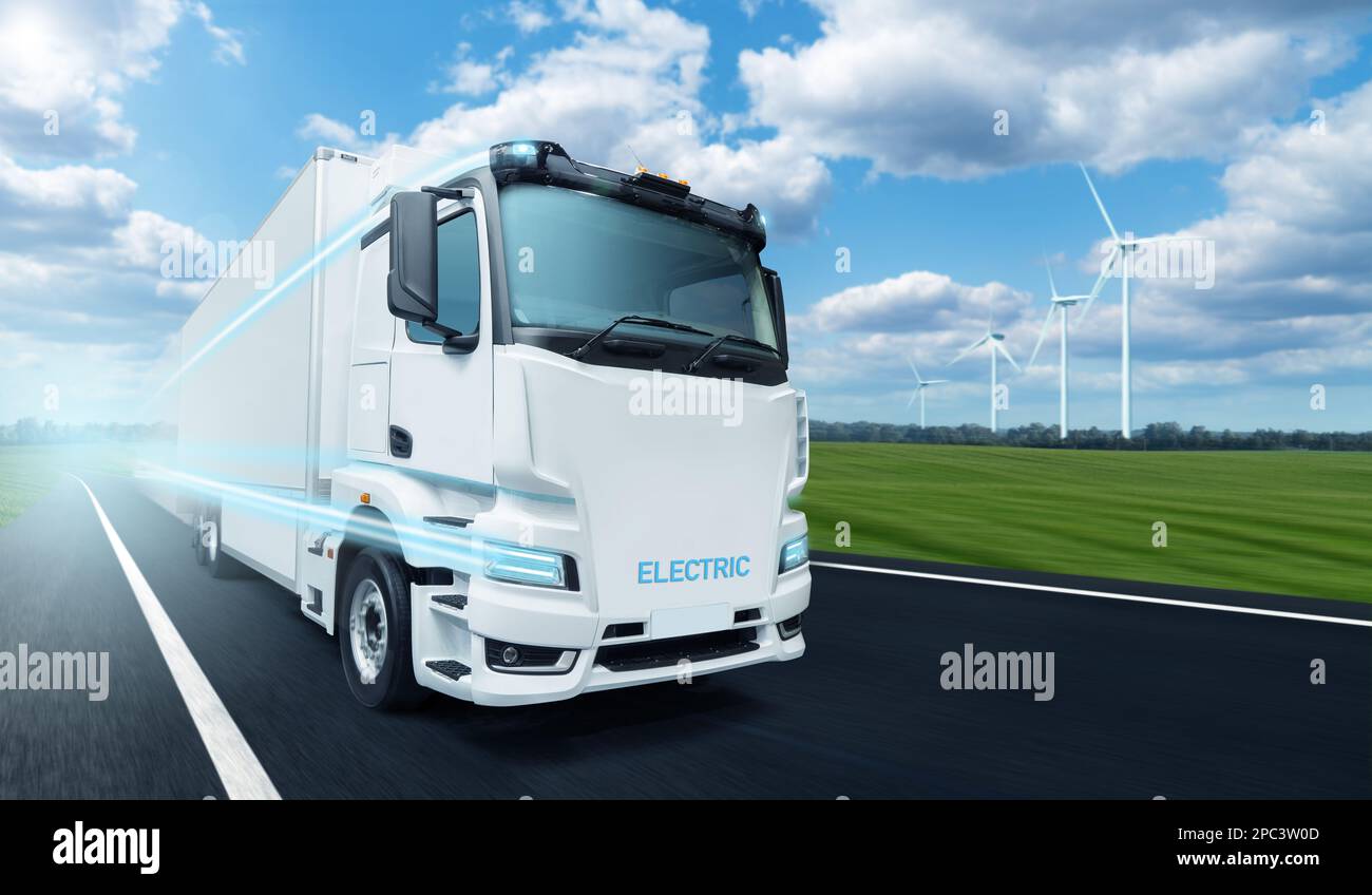 Concept of white electric truck on a road with wind turbines on a horizon Stock Photo