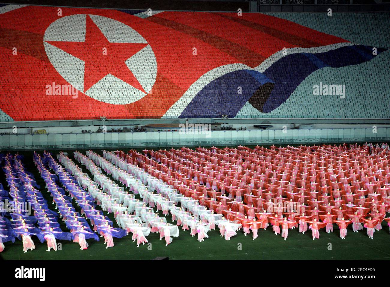 FILE **In this October 11, 2005 file photo, North Koreans perform with  scarves showing the colors of the North Korean flag near an image of the  flag formed by tens of, image size:1300x956