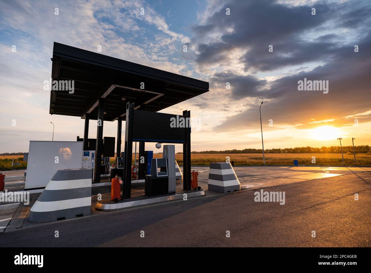 Modern self service gas station against the backdrop of a dramatic sunset sky Stock Photo