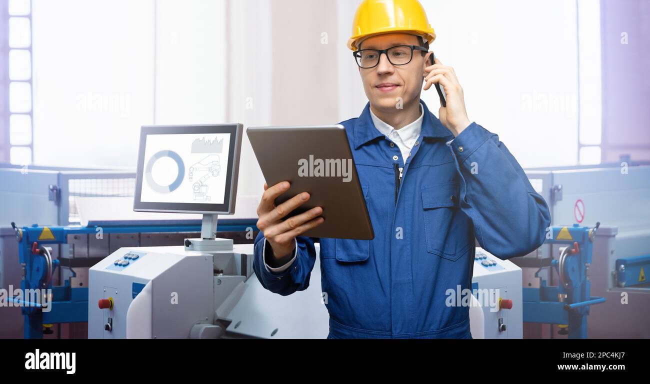 Engineer uses a digital tablet to control robots in a smart factory. Smart industry 4.0 concept Stock Photo