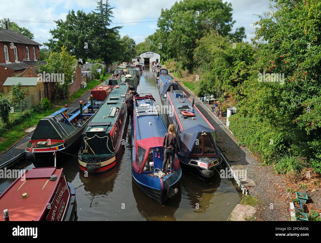 A narrowboat manoeuvring towards the dry dock at Norbury Junction, Shropshire Union Canal, England. Stock Photo
