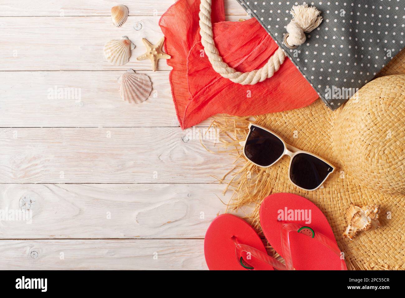 Straw hat sunglasses flip flops and beach bag with scarf on white ...