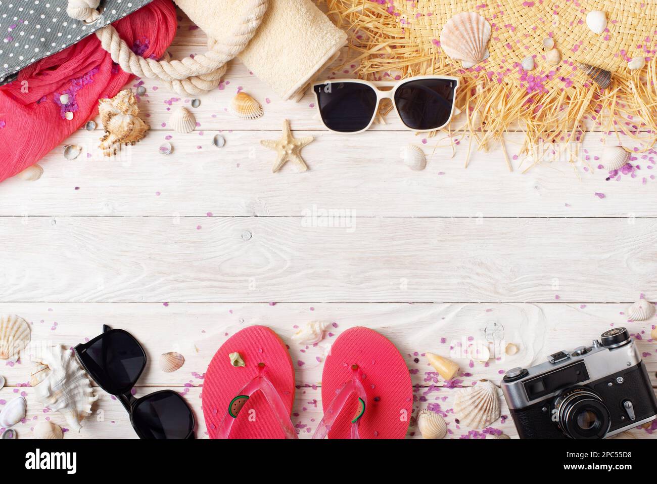 Camera straw hat sunglasses flip flops and beach bag on white wooden ...