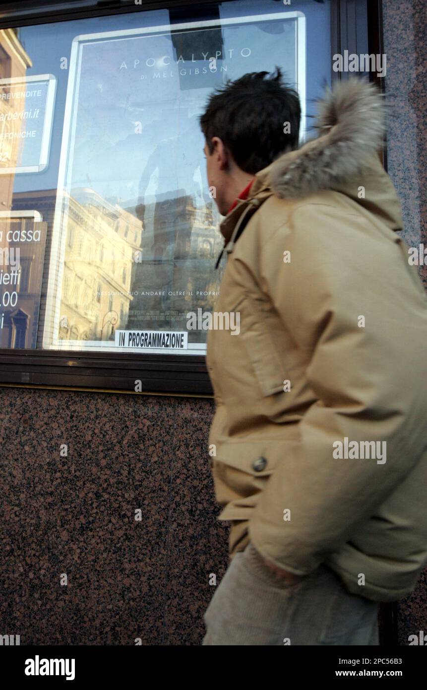 A teenager walks past a poster of Mel Gibson’s Apocalypto outside