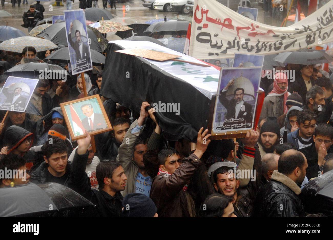 Lebanese Sunni Muslims hold a coffin and pictures of Iraq's executed ...