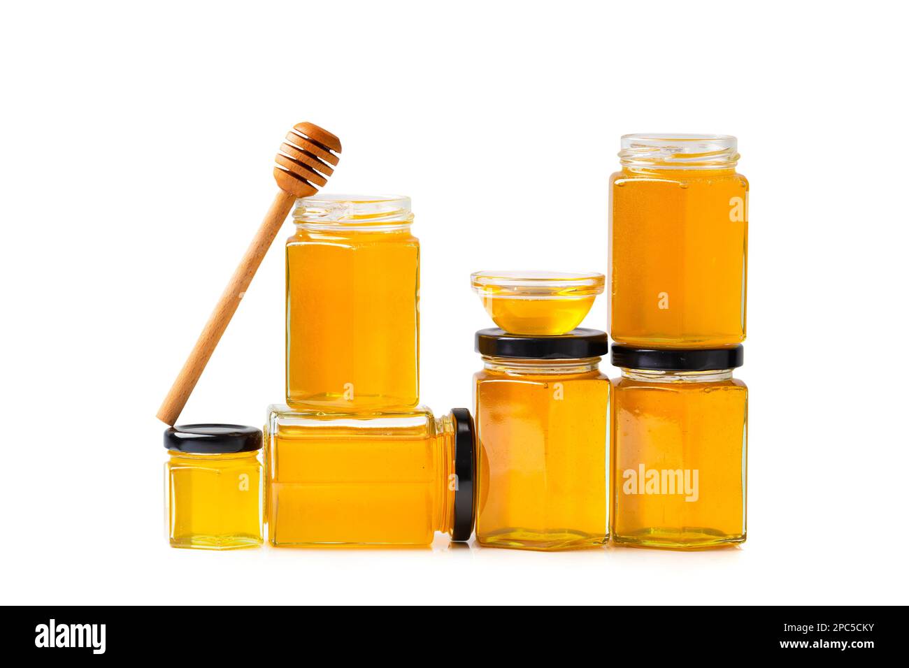 Honey in glass jars with honey stick. Organic honey in jars on a white
