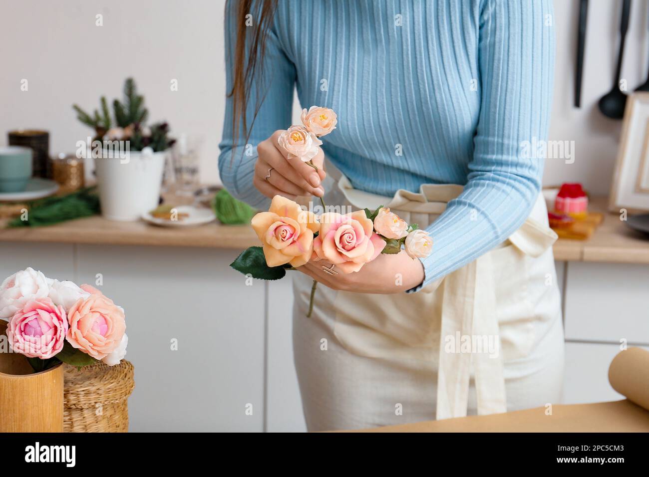 Girl florist makes a bouquet. Bouquet of soap close-up in the hands of a florist. Roses and tulips in the hands of a girl Stock Photo