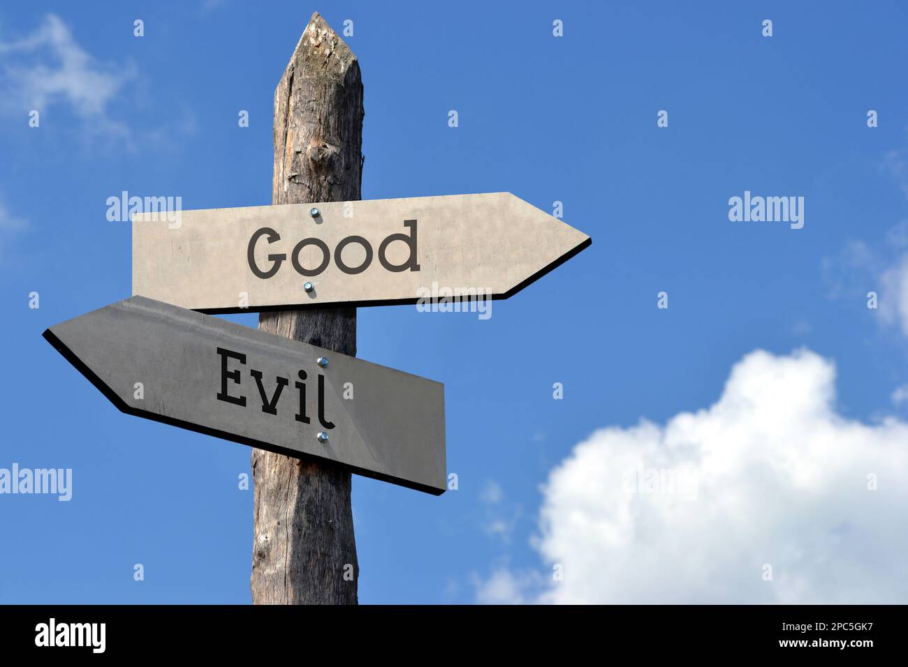 Good or evil - wooden signpost with two arrows, sky with clouds Stock ...