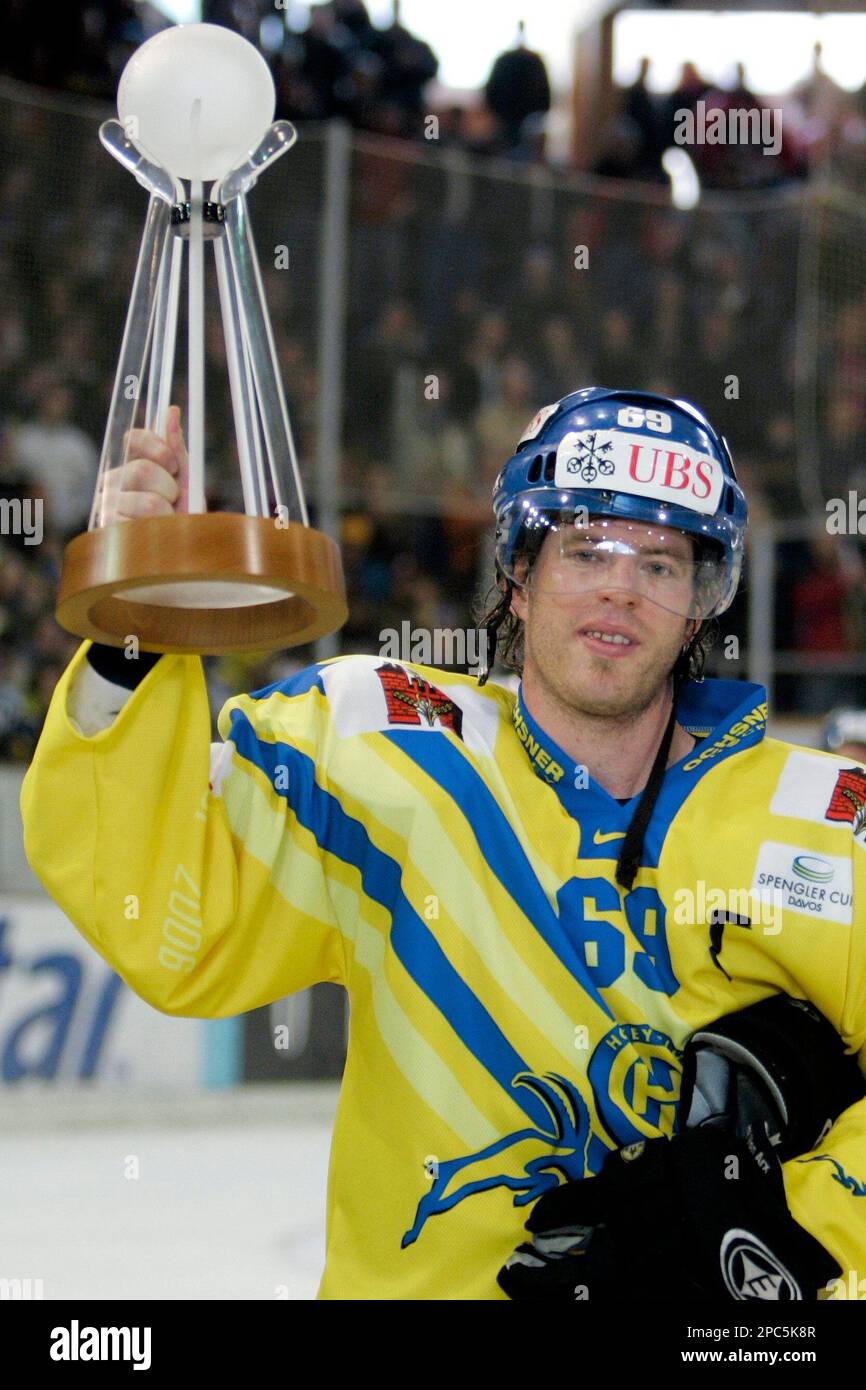 Swiss HC Davos player Sandro Rizzi lifts the winners trophy of the 80th Spengler Cup after the final game between HC Davos and Team Canada at the Spengler Cup ice hockey tournament,