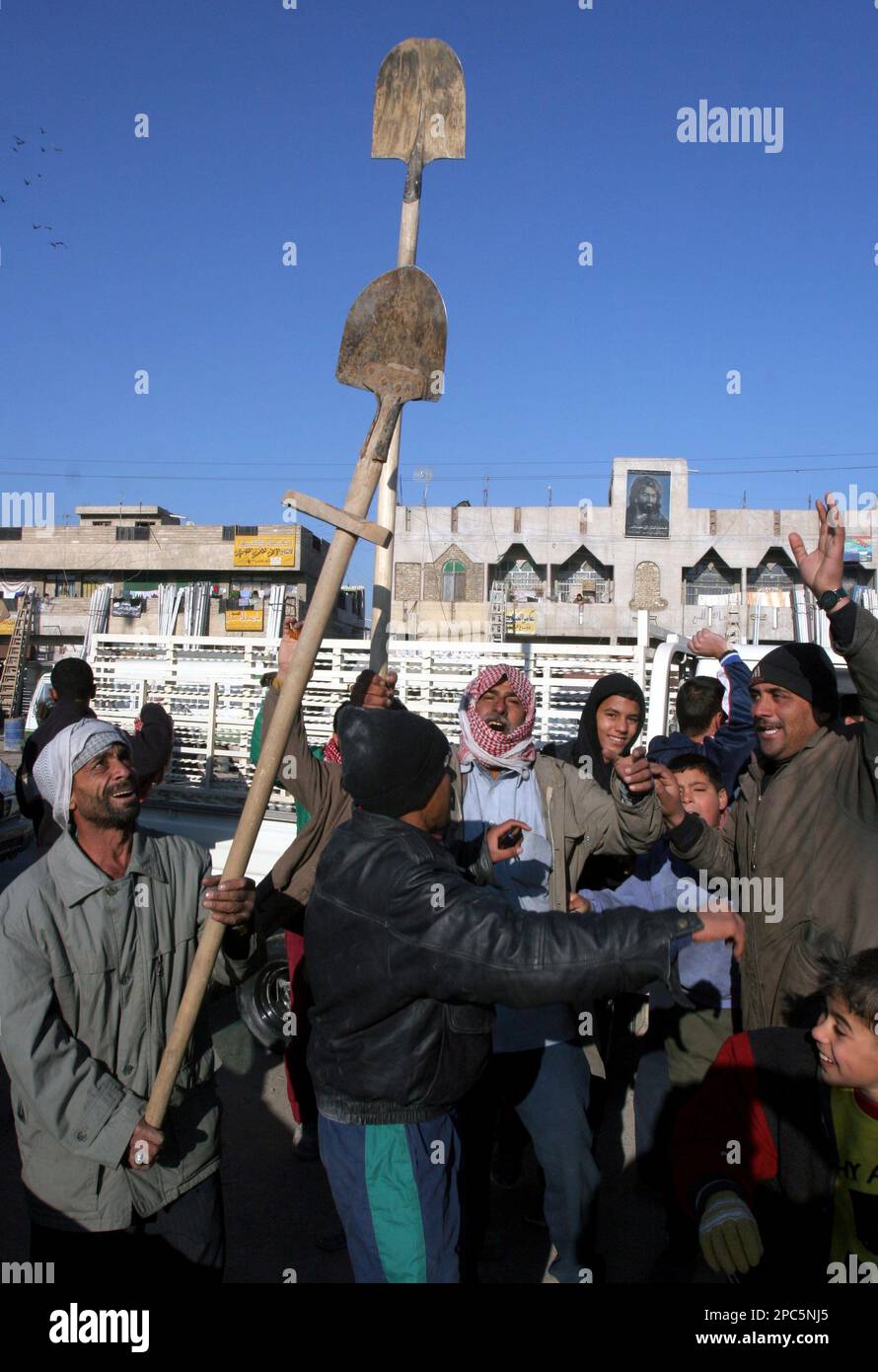 Iraqis celebrate after hearing news of the former Iraqi president Saddam Hussein being executed in Baghdad's Shiite slum of Sadr City, Iraq, Saturday, Dec. 30, 2006. Saddam Hussein, the dictator who ruled Iraq with a remorseless brutality for a quarter-century and was driven from power by a U.S.-led war that left his country in shambles, was taken to the gallows and executed Saturday. (AP Photo/Karim Kadim) Stock Photo