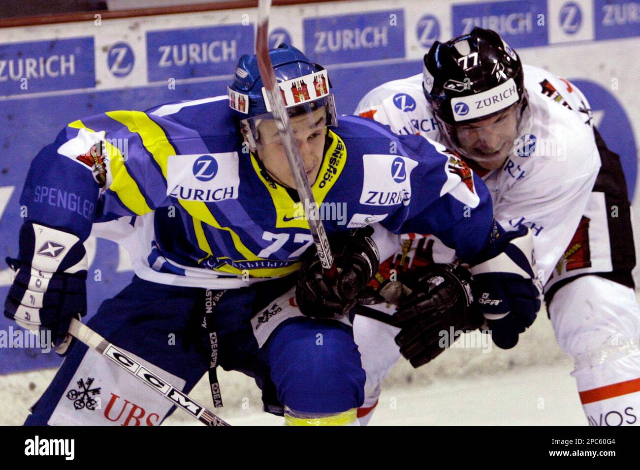 Russias Khimik player Maxim Semenov, left, fights for the puck with Swedens Mora IK player Martin Jansson, right, during the game Mora IK against Khimik at the 80th Spengler Cup ice hockey