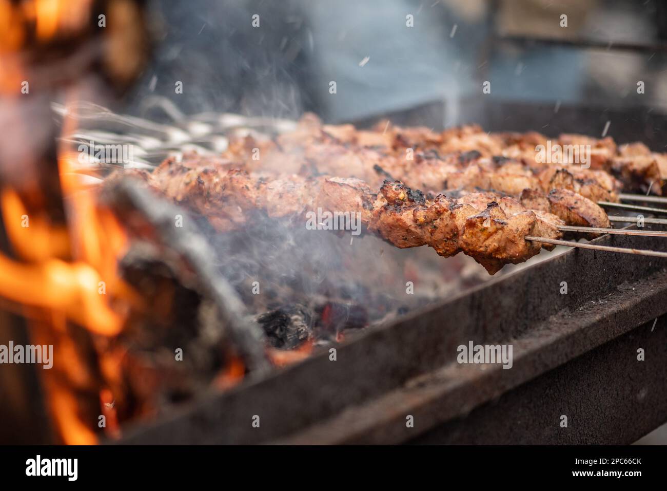 Pork meat skewer, grilled or roasted in a barbecue with pitchforks on