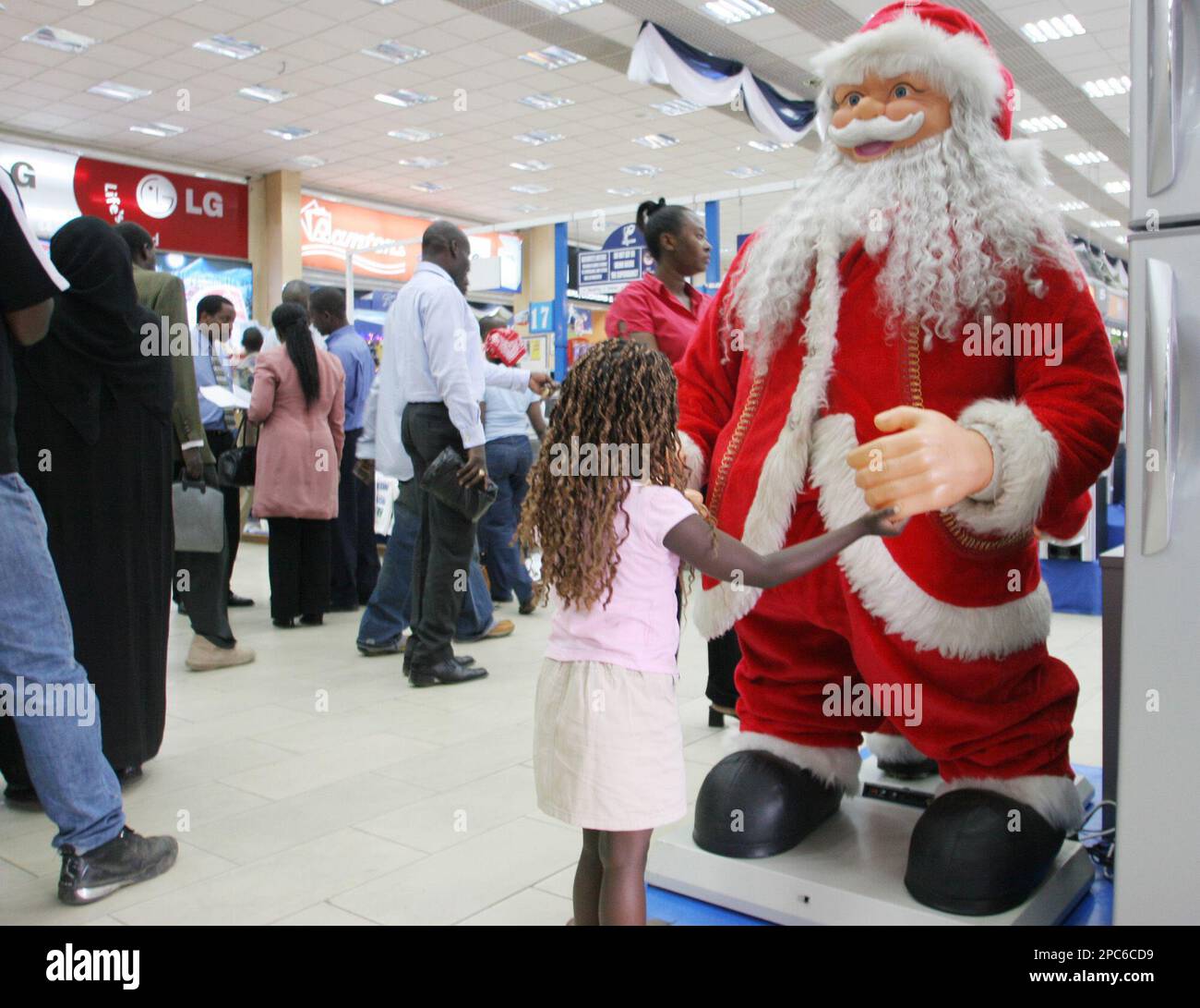 A child plays with a Santa Claus display modal at a shopping mall in