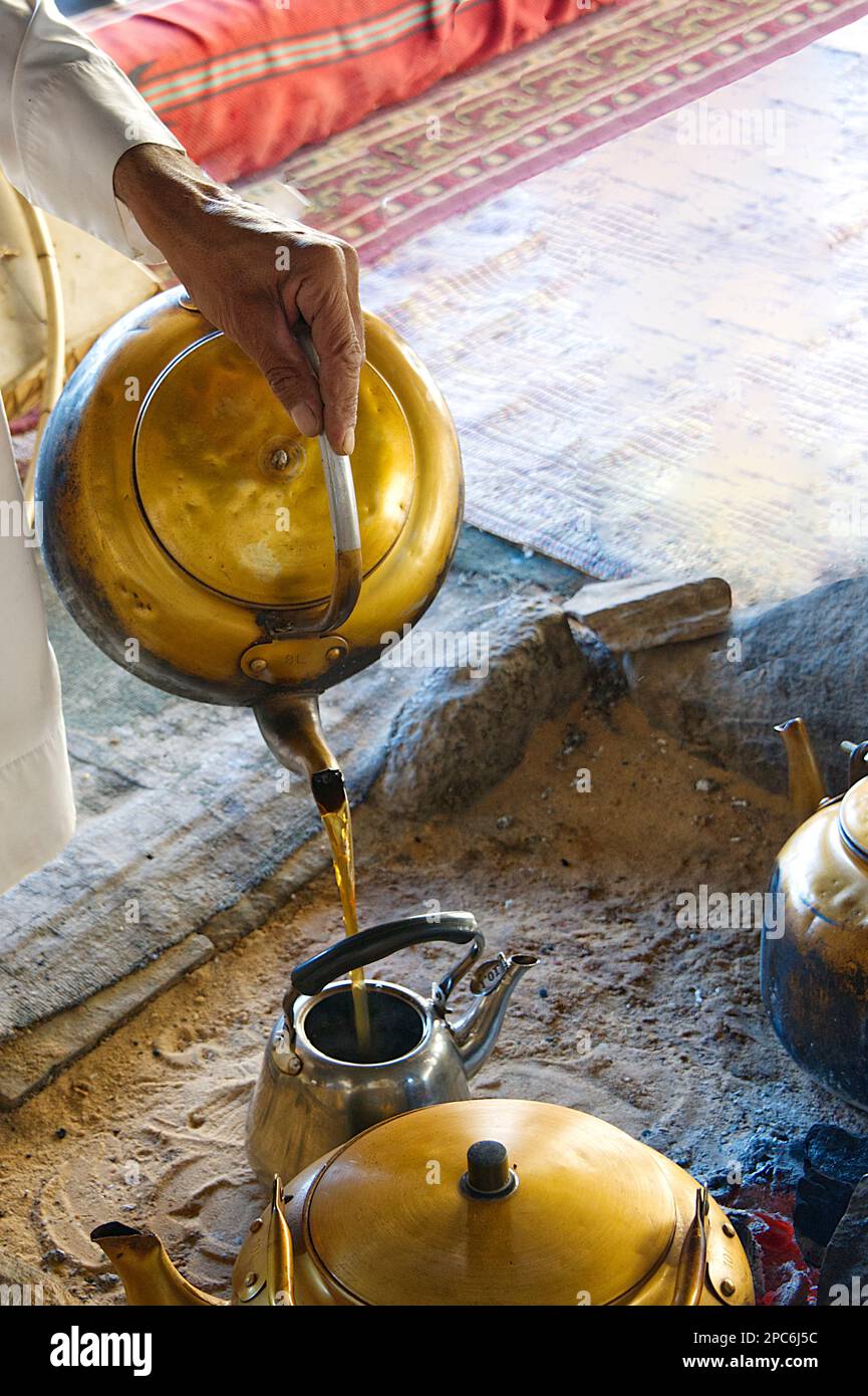 Hand of a man preparing the tea in a metal teapot Stock Photo
