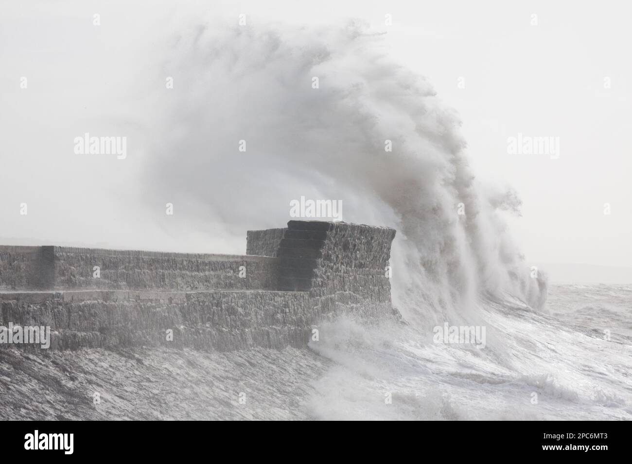 Porthcawl, South Wales, UK.  13 March 2023.  UK weather: Large waves crash over the breakwater this morning, as gales of 55mph hit the region.  Credit: Andrew Bartlett/Alamy Live News Stock Photo