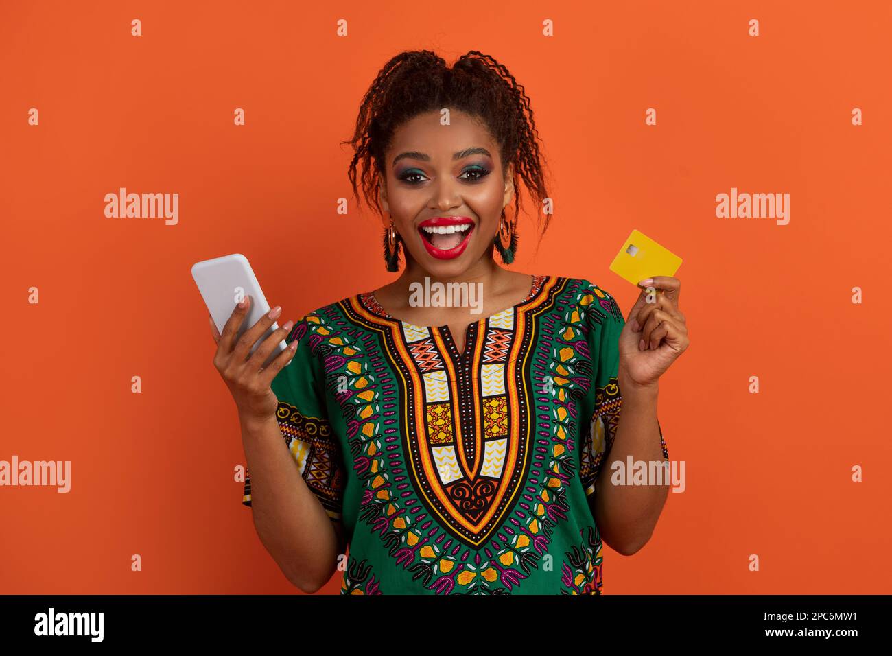 Emotional black woman holding smarphone and bank card Stock Photo Alamy