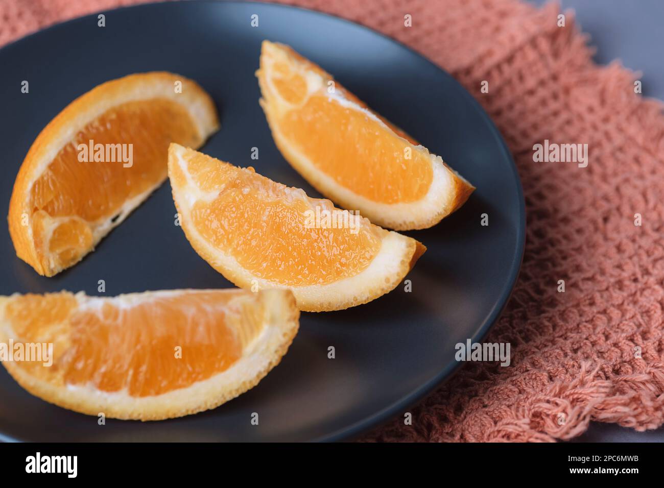 Orange slices on black plate, closeup. Selective focus. Stock Photo