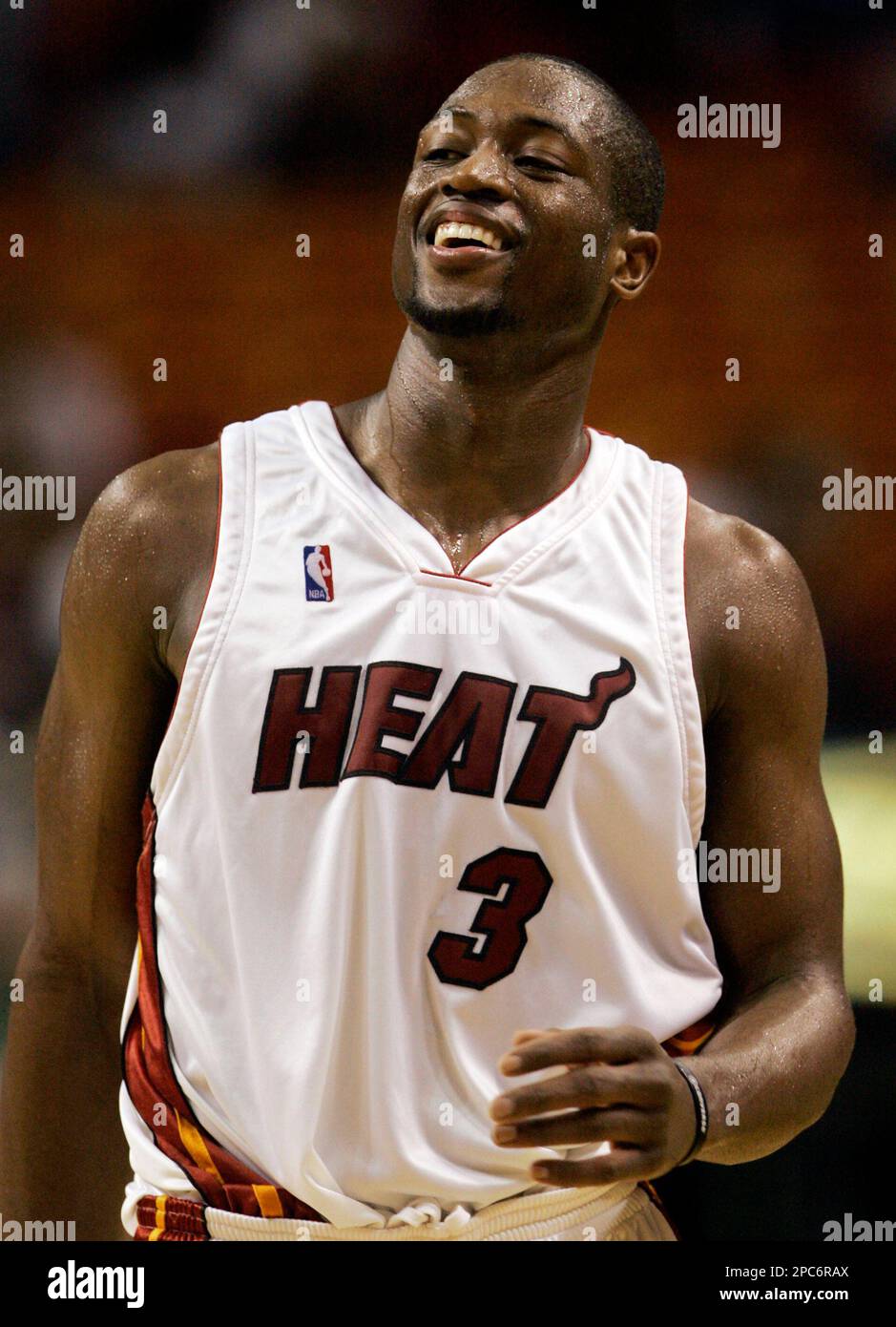 The Miami Heat's Dwyane Wade, left, holds a jersey with the number 11 that  honors his former agent Henry Thomas, who died in 2018, while teammate  Udonis Haslem, right, holds Wade's jersey