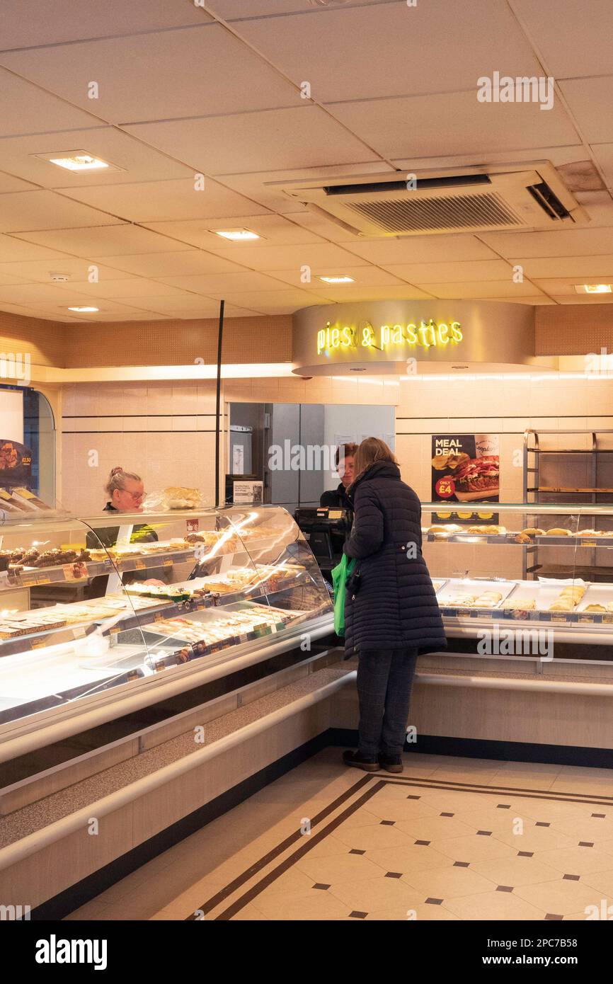 Woman OAP shopping for fresh bread at a Cooplands Bakery in