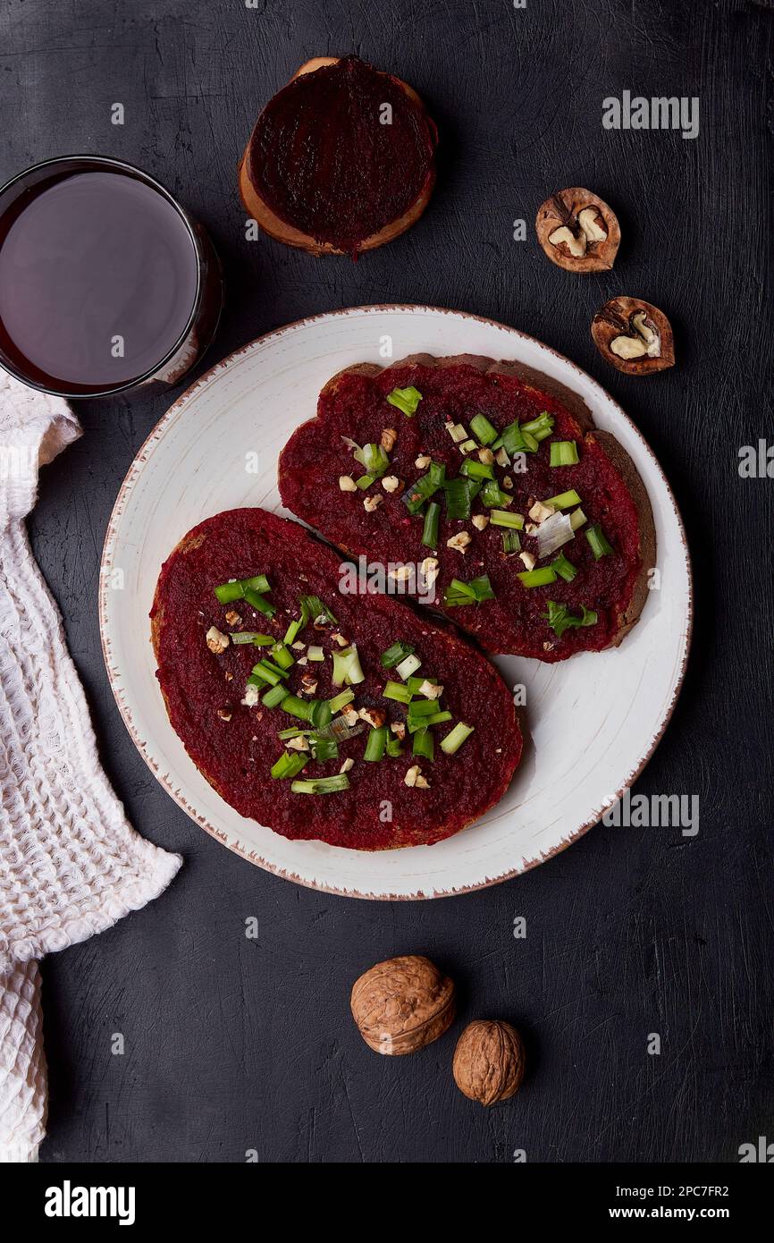 Vegan beetroot spread sandwiches with young onion, garlic and cottage cheese. Vegetarian seasonal food flat lay. Stock Photo