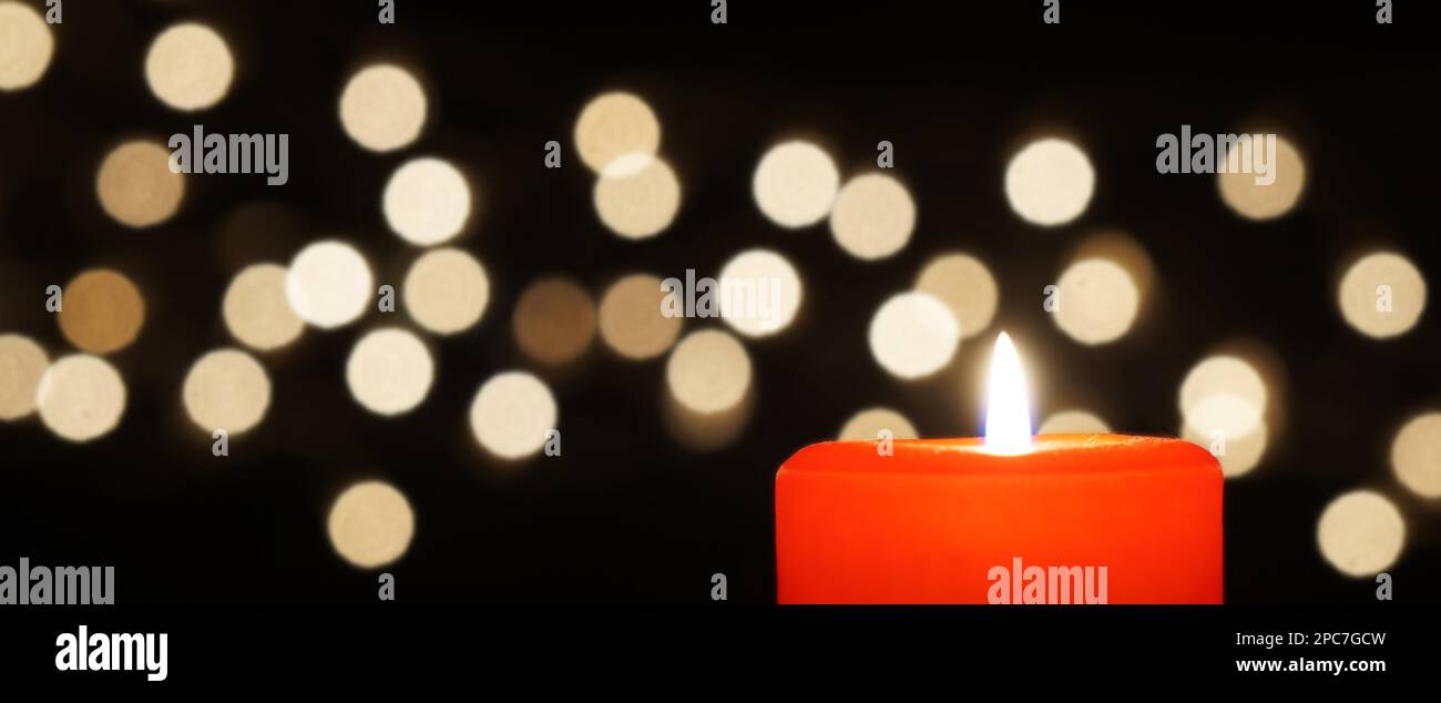 banner with red candle and christmas lights bokeh Stock Photo