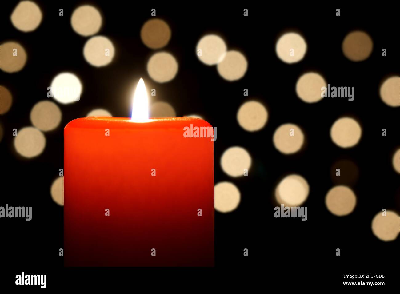 red candle close-up with christmas lights bokeh background Stock Photo
