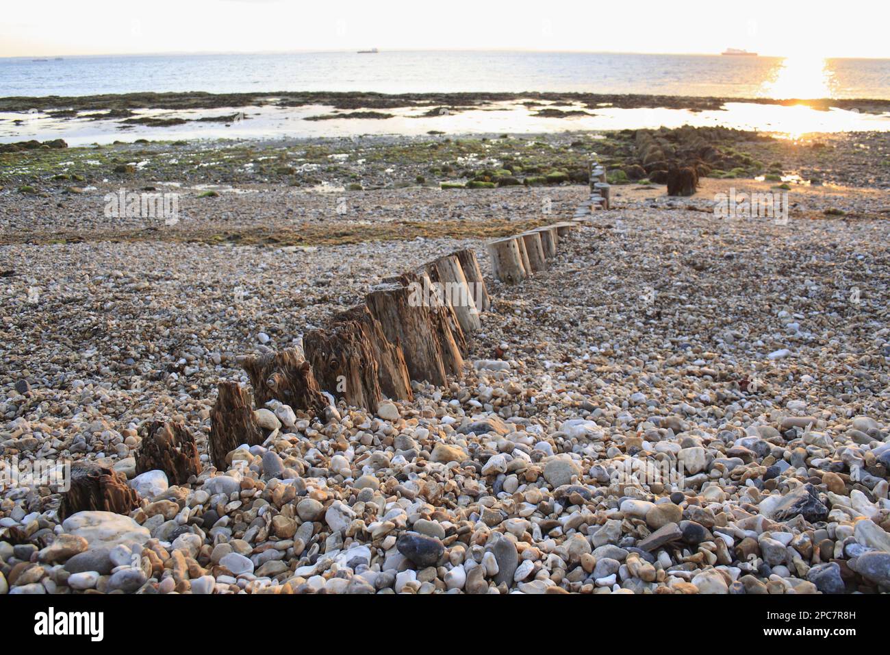 Remains of breakwater on beach with incoming tide at dawn, Bembridge, Isle of Wight, England, United Kingdom Stock Photo