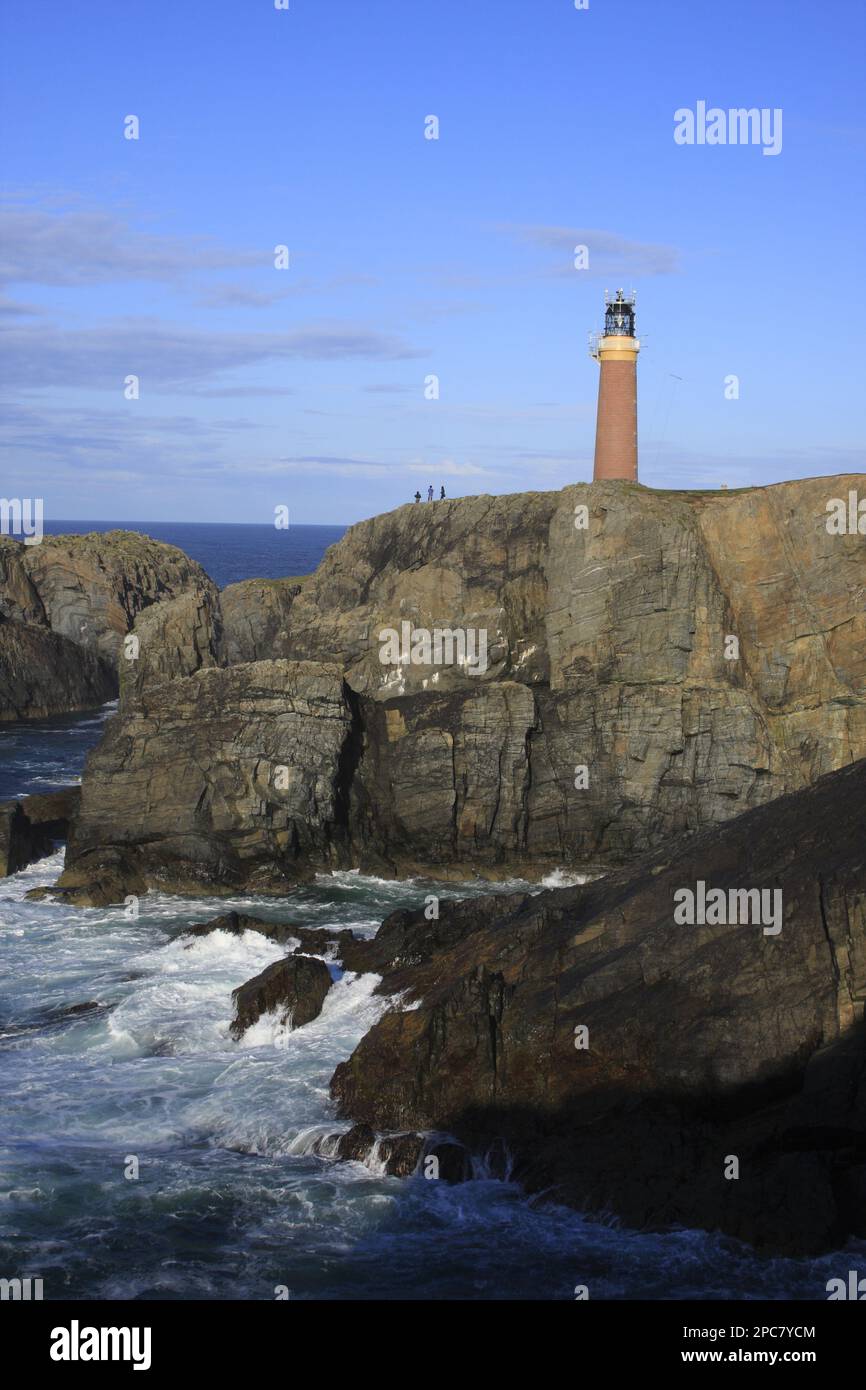 View of coastal cliff with lighthouse and tourists, Butt of Lewis, Isle ...