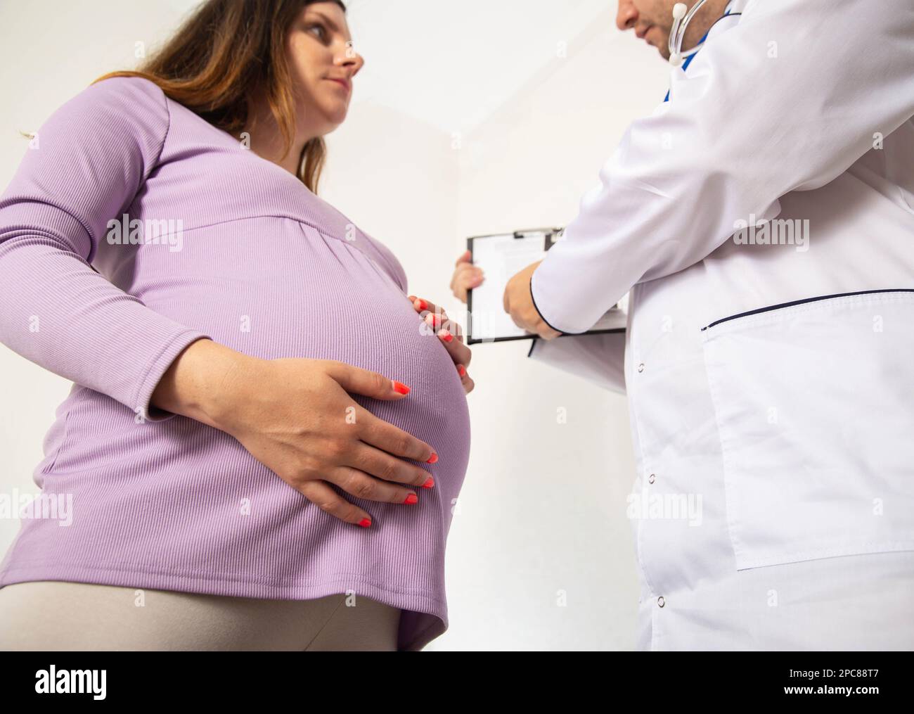 A pregnant woman is talking to a doctor psychologist. The concept of psycho-emotional disorder during pregnancy. Stress and anxiety, maternity Stock Photo