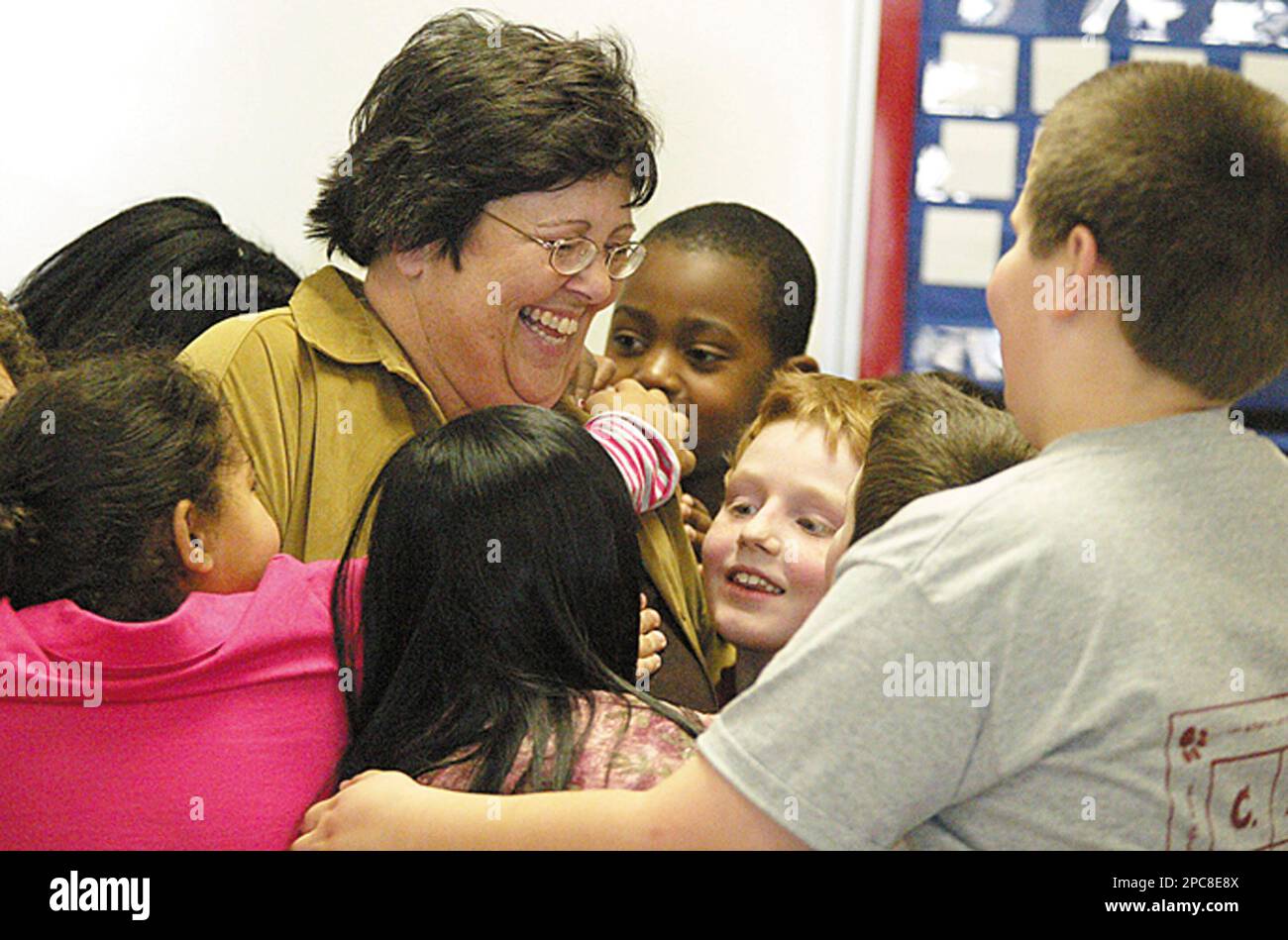 Brenda Webb, a McRae Searcy Elementary School third grade teacher, receives  hugs from her students after Blue Bell Ice Cream served ice cream  sandwiches Monday, Dec. 4, 2006 in Searcy, Ark. (AP