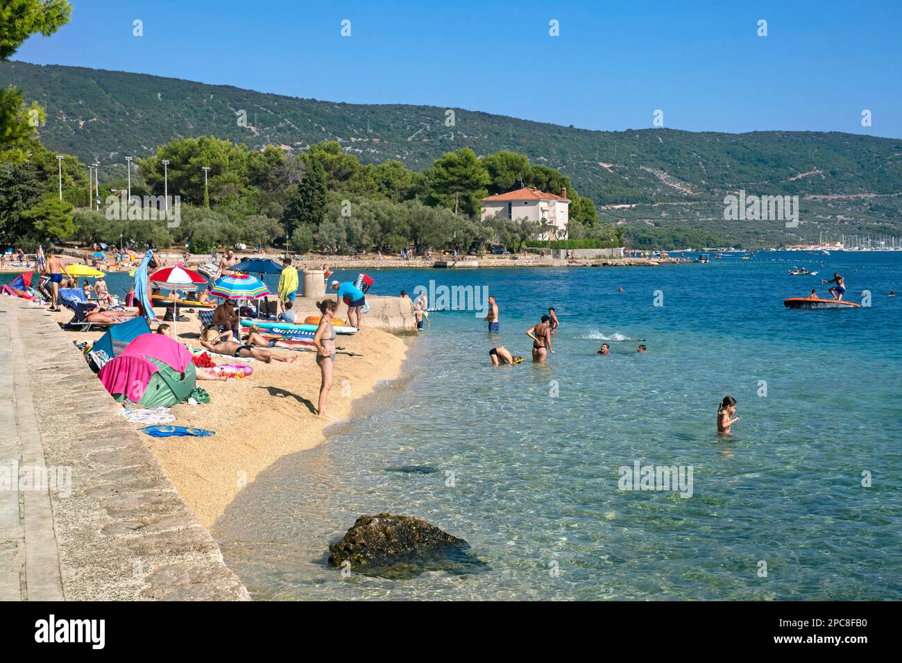 Sunbathers on sandy beach and tourists swimming in the Adriatic Sea near Cres on the island Cherso, Kvarner Bay, Primorje-Gorski Kotar, Croatia Stock Photo