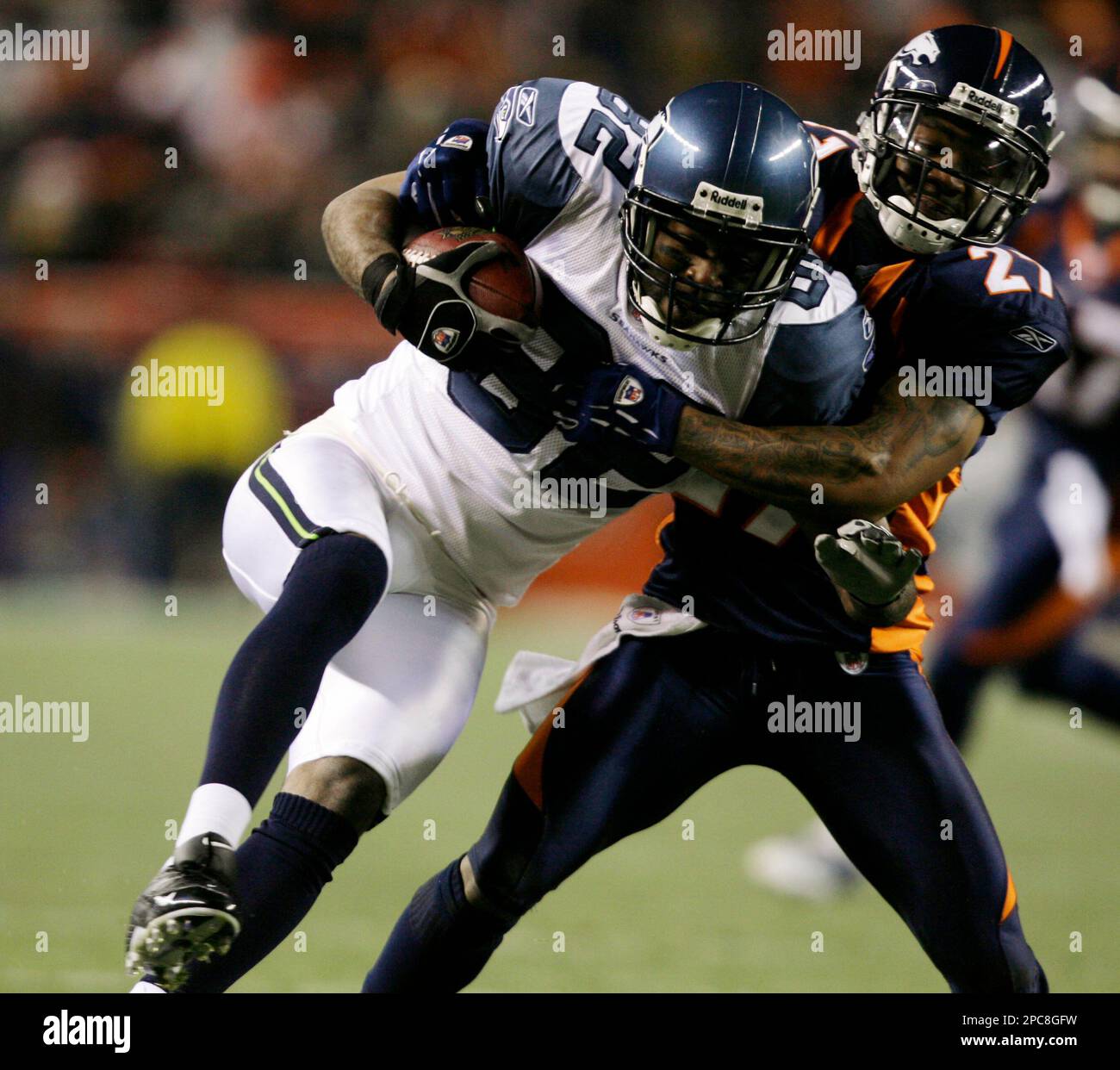 Seattle Seahawks wide receiver Darrell Jackson, left, is dragged down after  pulling in a pass for a short gain by Denver Broncos cornerback Darrent  Williams in the first quarter of an NFL