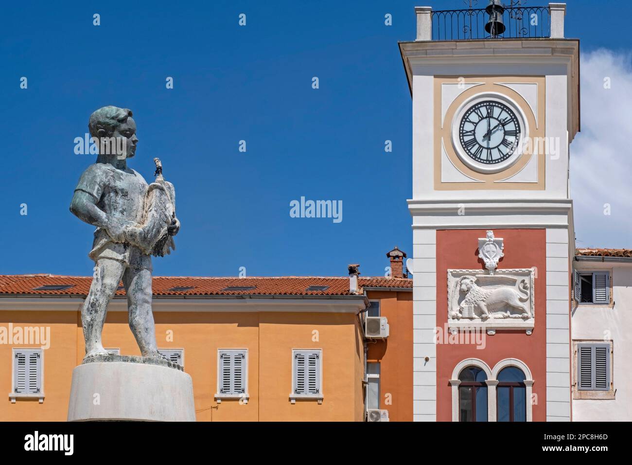 Boy with Fish fountain and 17th century red clock tower in the city Rovinj / Rovigno, seaside resort along the Adriatic Sea, Istria County, Croatia Stock Photo