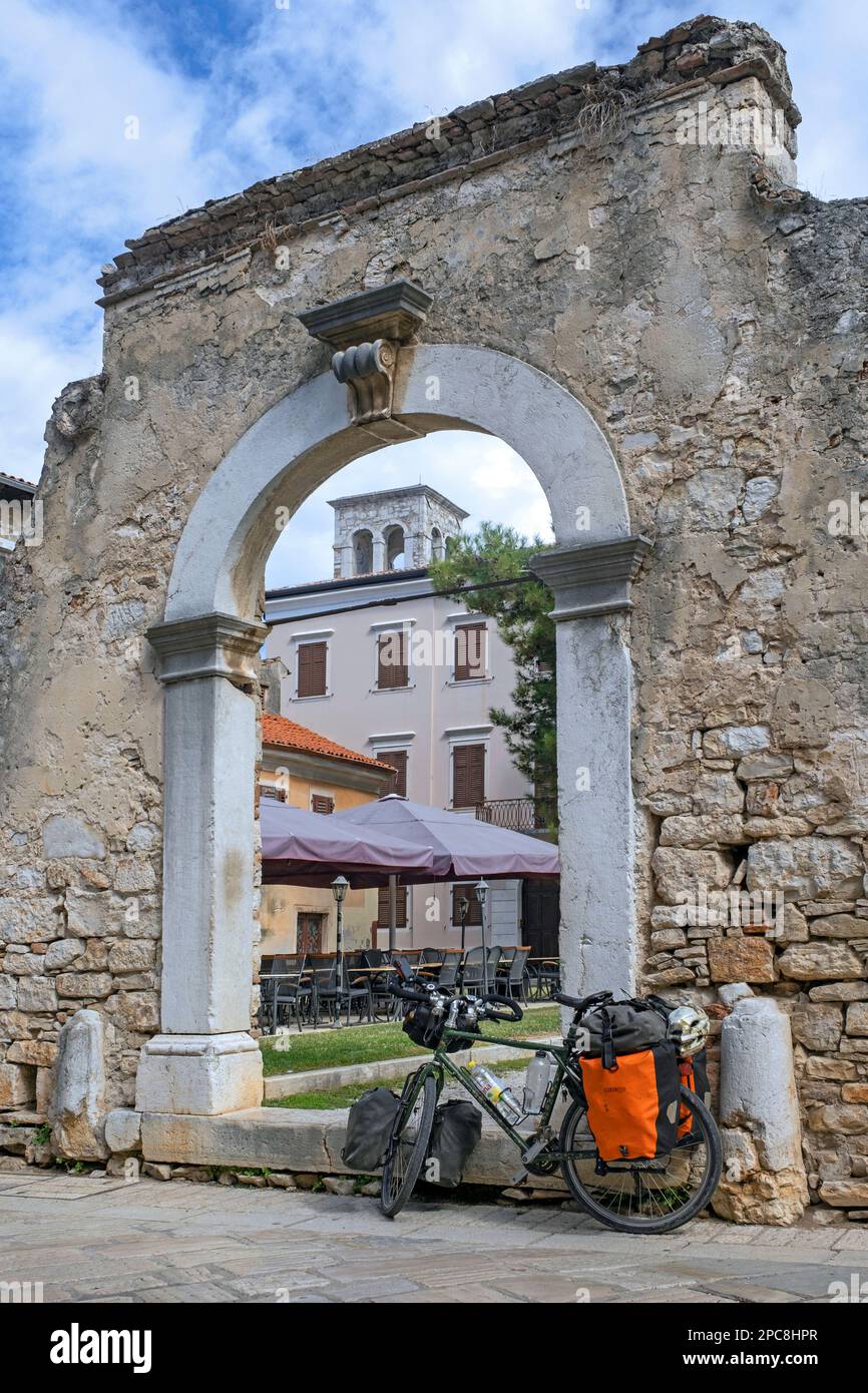 Touring bicycle in front of remains of ancient Roman city gate in the town Poreč / Parenzo, seaside resort at the Adriatic Sea, Istria County, Croatia Stock Photo