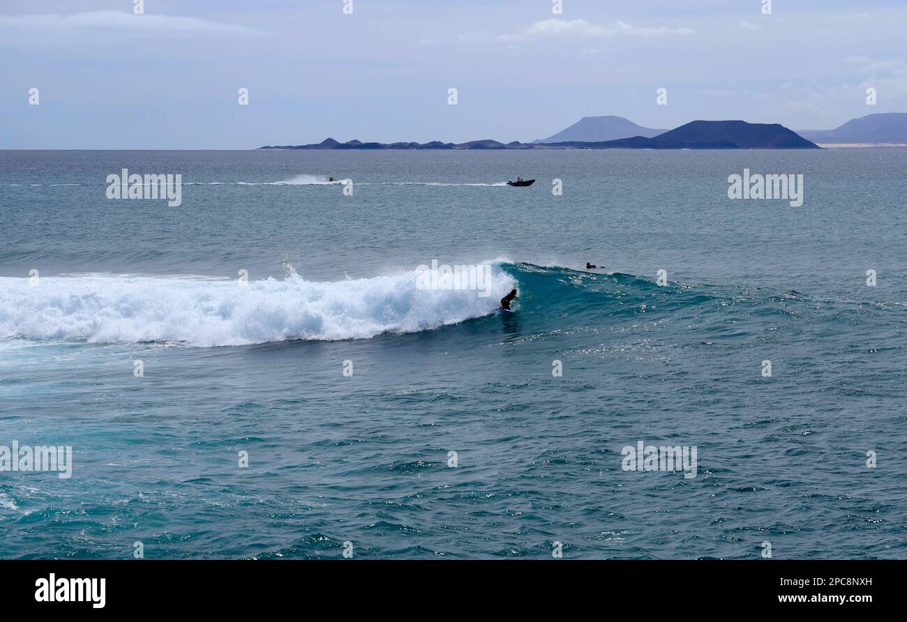 Surfer and crashing waves, Las Coloradas, Playa Blanca, Lanzarote, Canary Islands, Spain. Stock Photo