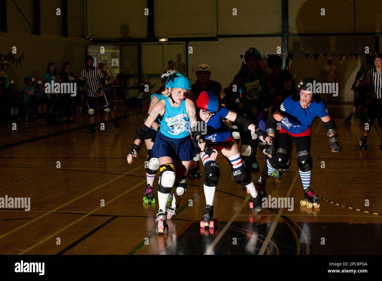 Dramatically lit roller derby engagement between a jammer with the star