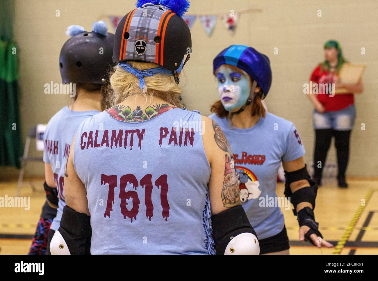 Three roller derby skaters in the mixed league team Scare Bears wait on